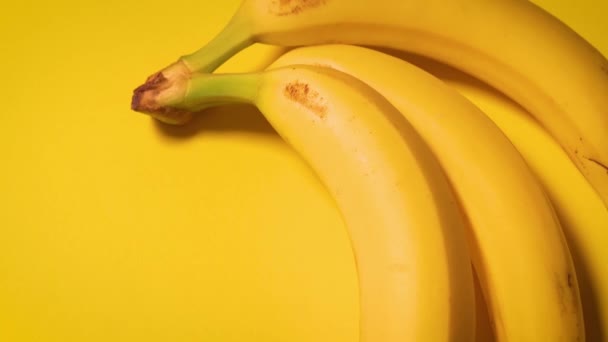 Frische Bananen auf gelbem, minimalistischen Hintergrund — Stockvideo