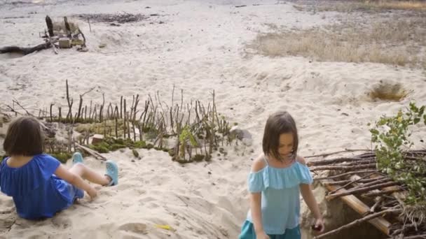 Dos niñas en vestidos de colores están jugando en la arena en el bosque — Vídeo de stock