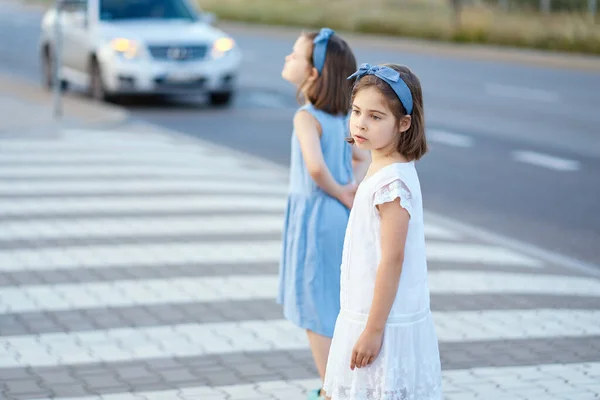 Gün batımında iki küçük tatlı kız şehir sokaklarında yürüyor. — Stok fotoğraf