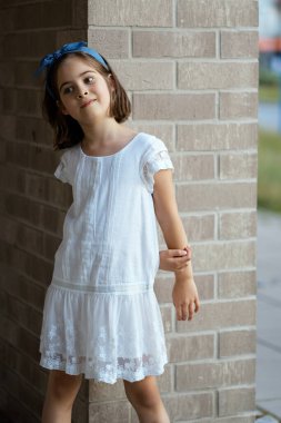 Güzel kız gün batımında şehir sokaklarında poz verir. 