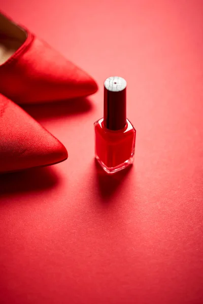 Red high heel shoes and nail polish on a minimalist background Stock Photo