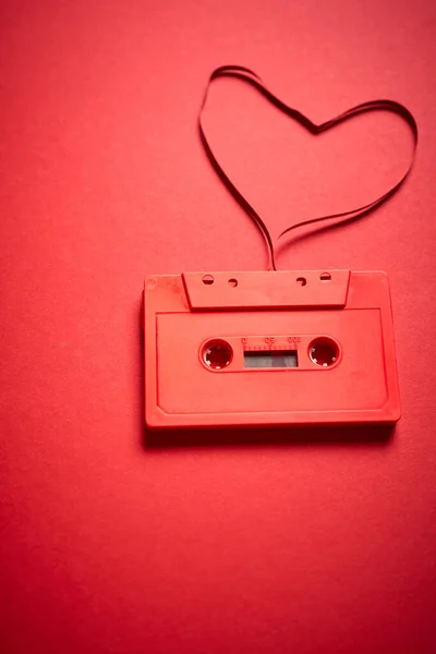 old red cassette tape on a minimalist background