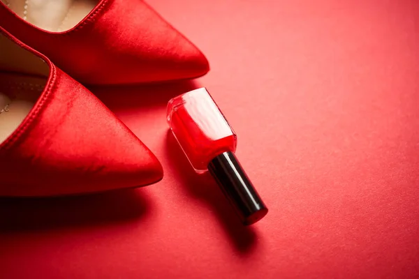 Red high heel shoes and nail polish on a minimalist background Royalty Free Stock Photos