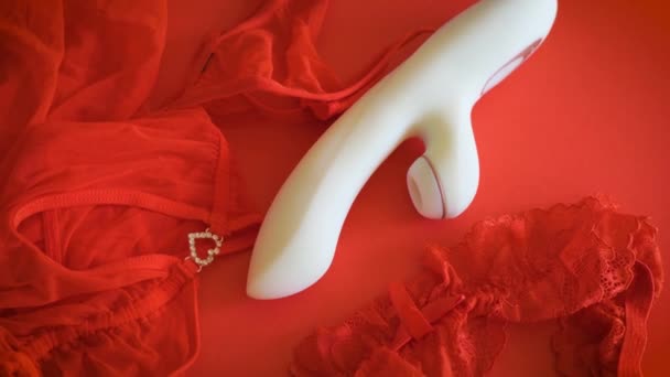 Putih vibrator mainan seks di latar belakang merah dengan pakaian — Stok Video
