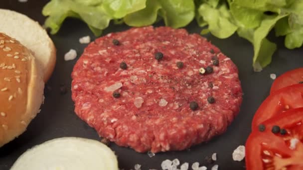 Färskt nötkött för burgare på bordet med salladslök och bröd — Stockvideo