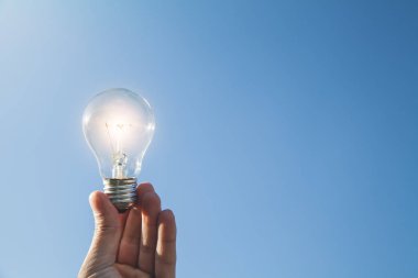 El ele tutuşan ampul. İlham ve yaratıcılık kavramı