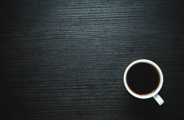 Koyu ahşap arka plan üzerinde beyaz kahve fincanı.