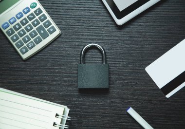 Asma kilit tablet: Not defteri ve ahşap arka plan üzerinde kredi kartı ile.