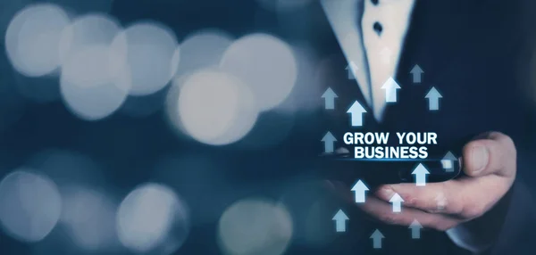 Man holding Grow Your Business words with growth arrows.