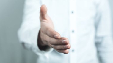 İş adamı tokalaşmak için elini uzatıyor. Anlaşma konsepti