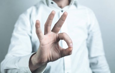 Başarılı iş adamı ok işareti yapıyor.