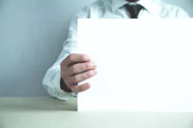 Boş beyaz kağıt tutan işadamı metin reklam.