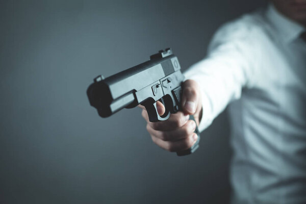 Caucasian man standing and aiming with gun.
