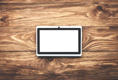 Ahşap bir masa üzerine beyaz dijital tablet.