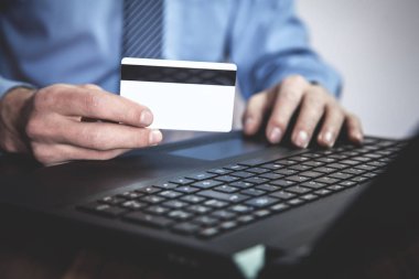 Laptop ve gösteren kredi kartı kullanan adam. İş kavramı