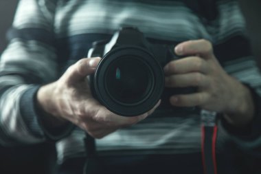 Profesyonel fotoğrafçı bir Dslr kamera tutarak.