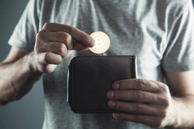 Beyaz adam Bitcoin cüzdan koyarak.