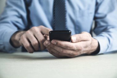 Masasında Smartphone kullanan adam. İş kavramı