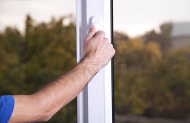 Erkek el Beyaz plastik pvc pencere evde kapatın.