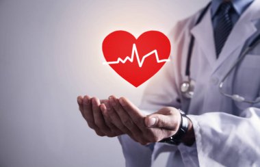 Kırmızı kalp kalp atışı ile tutarak stetoskop ile ayakta doktor.