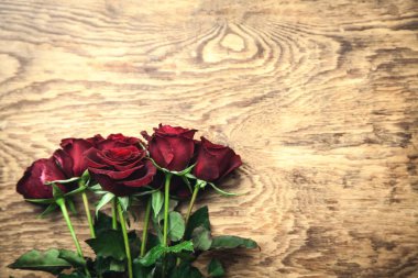 Ahşap arka planda kırmızı güller.