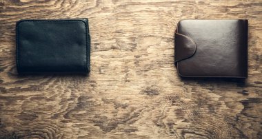 Ahşap arka plan üzerinde siyah ve kahverengi cüzdan.