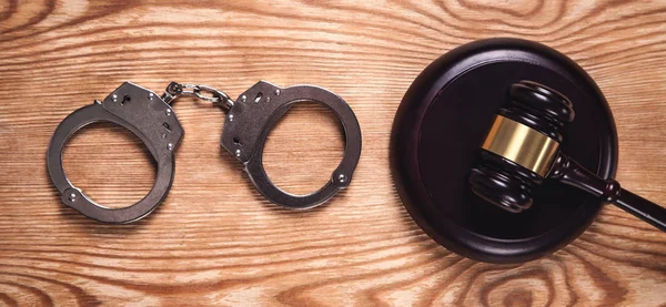 金属手錠と木製の背景に裁判官小槌 犯罪と法の概念 — ストック写真
