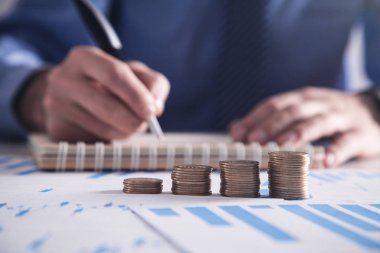  Adam masada sikke yığını ile not etmek yazma. Kavramı finans ve yatırım