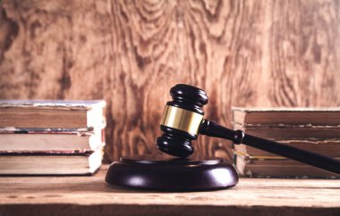 Ahşap yargıç tokmak ve ahşap masa üzerine kitaplar. Hukuk ve adalet