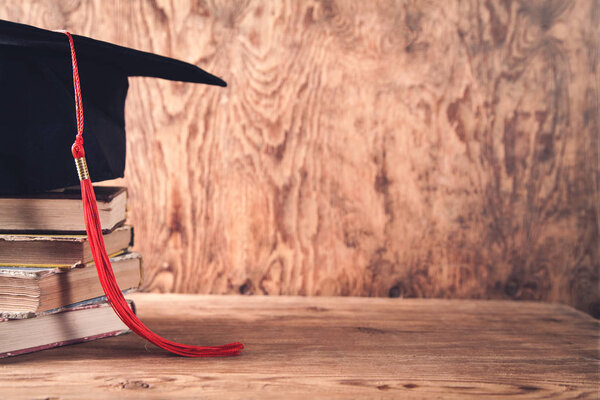 Graduation hat with books on table. Education concept