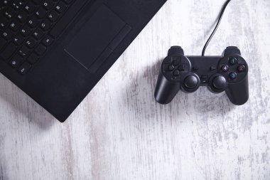 Oyun kumandası ile laptop. Video oyunları oynarken 