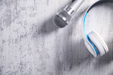 Mikrofon ve kulaklık beyaz masa üzerinde. Üstten Görünüm