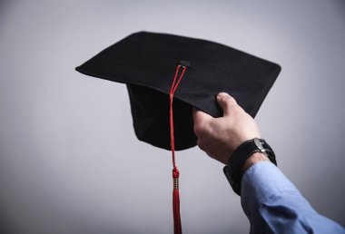 Mezuniyet şapka tutan adam el. Eğitim