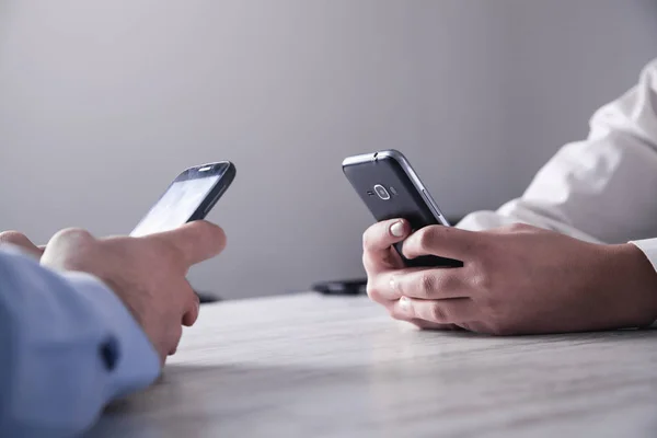 Two business people holding smartphone.