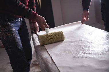 Adam rulo duvar kağıdı ahşaba yapıştıran bir ürüne. Daire onarım