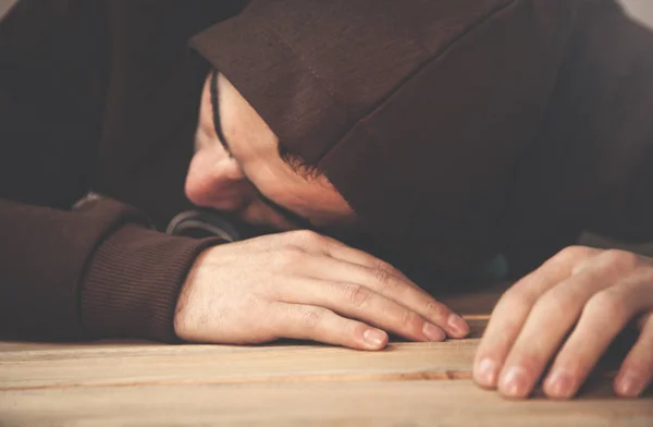 Kapuzenmann schläft auf dem Schreibtisch. — Stockfoto