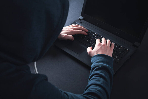 Hacker with laptop. Computer crime