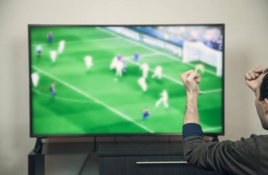Beyaz adam futbol smart TV izlerken.