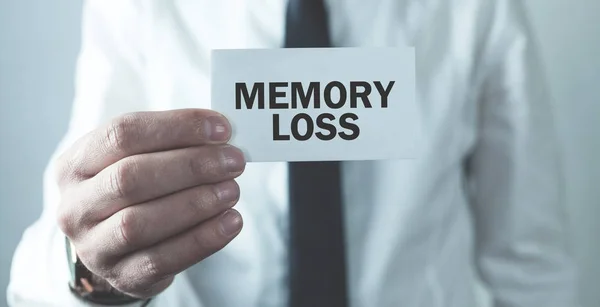 Man holding Memory Loss text on business card.