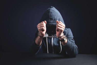 Bilgisayar korsanı kelepçeli. Siber suç