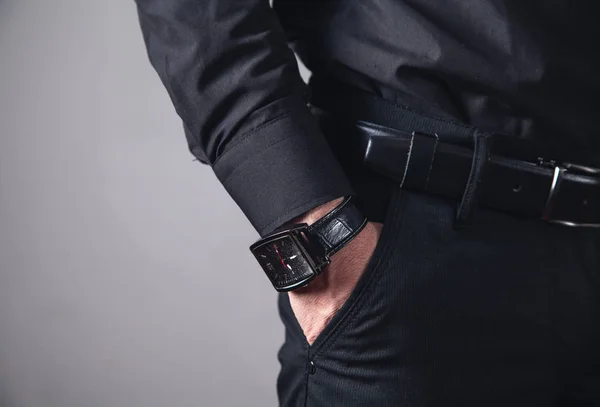 Hand in pocket with wrist watch.