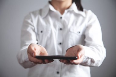 Kız akıllı telefon tutuyor. Teknoloji