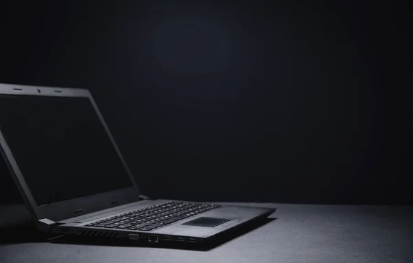 黑色笔记本电脑在黑色写字台上。技术概念 — 图库照片
