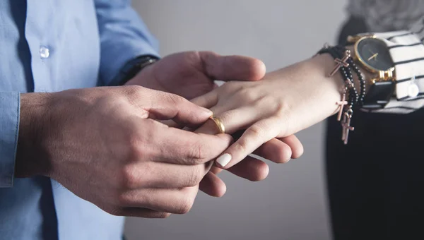 El hombre pone un anillo en la mano de una chica . — Foto de Stock