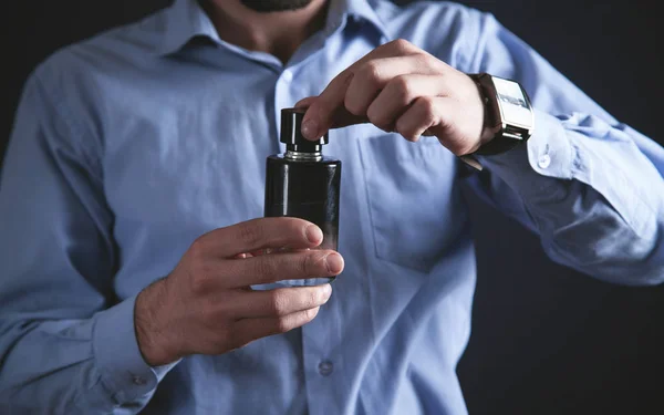 Homem segurando uma garrafa de perfume. — Fotografia de Stock