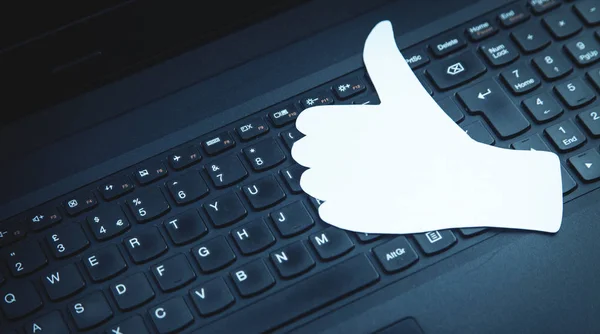 Papel polegares para cima sinal no teclado do laptop. Conceito de rede social — Fotografia de Stock