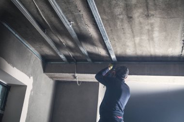Bir tavan inşaatının metal profiliyle çalışmak.