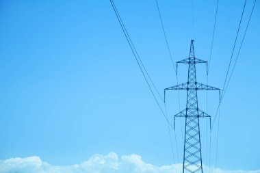 Mavi gökyüzünde elektrik hattı var. Yüksek voltaj kuleleri