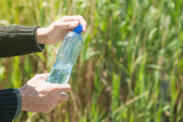 Man holding plastic water bottle in outdoor. — Stock Photo, Image