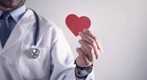 Doctor sosteniendo corazón de papel rojo. Atención médica y cardiología concep — Foto de Stock